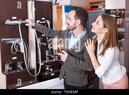 Junges Paar Auswahl neuer mixer Dusche im Bad Armaturen zu speichern. Fokus auf beide Personen Stockfoto