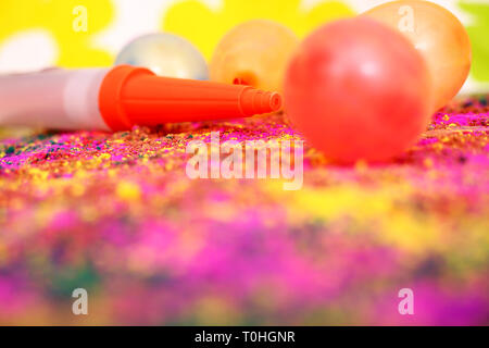 Bunte Luftballons und pichkari Für holi Spaß. Auf dem bunten Hintergrund isoliert. Stockfoto