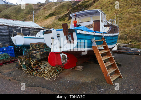 Ein altes Fischerboot und Hummer/Crab creel im Hafen von Portknockie, Schottland, Großbritannien. Stockfoto