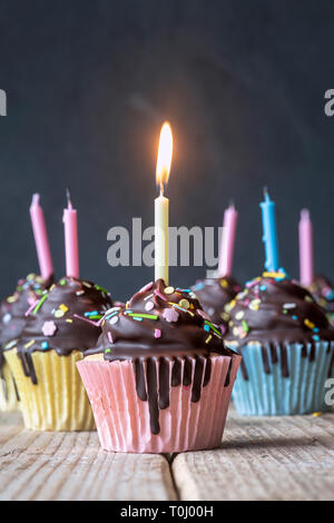 Geburtstag Geburtstagskuchen mit Kerzen. Vanille Cupcakes mit Baiser Zuckerguss und dunkle Schokolade shell Stockfoto