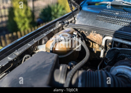 Alte Vorratsbehälter für Kühlflüssigkeit im Motorraum. Stockfoto