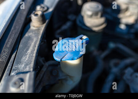 Vorratsbehälter der Scheibenwaschanlage mit blauem Verschluss, im Motorraum. Stockfoto