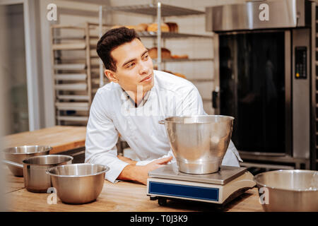 Baker tragen weiße Uniform in der Nähe von Küchenwaage Stockfoto