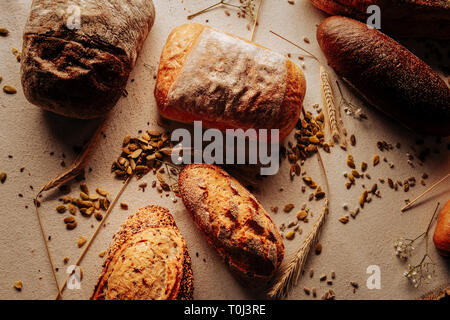 Fünf Laibe von Weizen und Roggen Brot auf dem Tisch liegen in Bäckerei Stockfoto