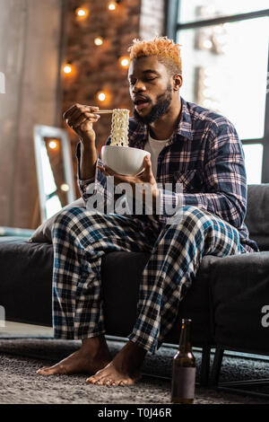 Gut aussehende hungrigen Mann seine Mahlzeit in Stockfoto