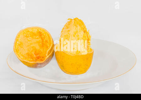 Aegle marmelos, Bael, Bael Frucht, der Elefant Apple, auf der Platte mit dem weißen Hintergrund. Stockfoto