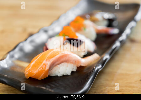 Japan roher Lachs Sushi und frische Mischung Sushi in schwarz Platte - Japanisches Essen im Japanischen Restaurant. Stockfoto