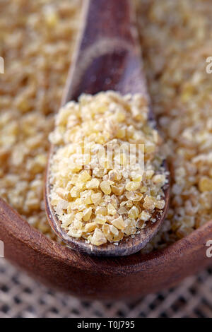 Ungekocht raw Bulgur weizen Körner in Houten Stockfoto