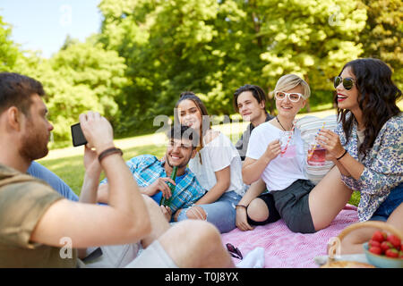 Kerl sie Bilder von Freunden auf Sommer Picknick Stockfoto