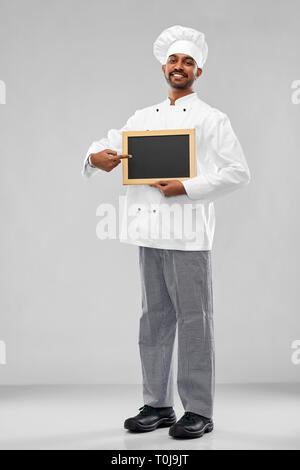 Gerne männliche indische Koch in Toque mit schiefertafel Stockfoto