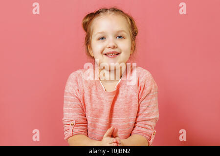 Closeup Portrait von niedlichen kleinen Kind Mädchen mit Brötchen von Haar über rosa Hintergrund Stockfoto