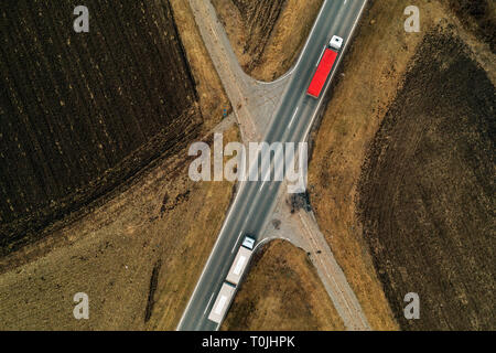 Lkw auf der Straße, Luftaufnahme von Fracht Transporter auf gerader Fahrbahn durch die ebene Landschaft Landschaft von Drone pov Stockfoto