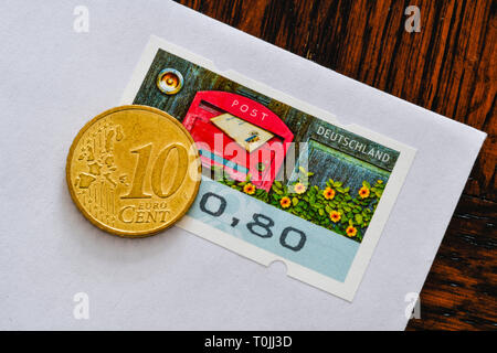 Deutsche Briefmarke 80 Cent und 10 Cent Münzen, symbolische Foto Portoerhöhung, Deutsche Briefmarke 80 Cent und 10 Centmünze, Symbolfoto Portoerhöhung Stockfoto