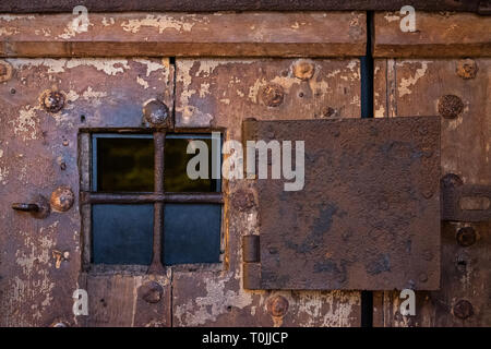 Rostigen Stahl Fenster auf sehr alte Holztür auf Gefängnis der Burg von Ljubljana in Slowenien, Europa Stockfoto