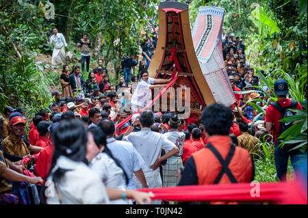 März 14, 2019 - Tana Toraja, Südsulawesi, Indonesien - Bewohner ziehen rotes Tuch und Särge ihre Verwandten während der Rambu Solo Ritual in Tana Toraja Regency, Südsulawesi. gesehen. Rambu Solo ist ein Trauerzug für die Tana Toraja Gemeinschaft ihre Vorfahren zu ehren. Die Prozession besteht aus mehreren Veranstaltung Arrangements und dauert mehrere Tage. (Bild: © Hariandi Hafid/SOPA Bilder über ZUMA Draht) Stockfoto