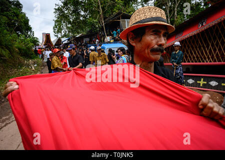 Tana Toraja, South Sulawesi, Indonesien. 14 Mär, 2019. Die Bewohner sind gesehen ziehen rotes Tuch und Särge ihre Verwandten während der Rambu Solo Ritual in Tana Toraja Regency, Südsulawesi. Rambu Solo ist ein Trauerzug für die Tana Toraja Gemeinschaft ihre Vorfahren zu ehren. Die Prozession besteht aus mehreren Veranstaltung Arrangements und dauert mehrere Tage. Credit: Hariandi Hafid/SOPA Images/ZUMA Draht/Alamy leben Nachrichten Stockfoto