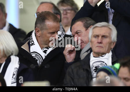 20. März 2019, Niedersachsen, Wolfsburg: Fussball: Länderspiel Deutschland - Serbien in der Volkswagen Arena. Herbert Diess (M links), Vorsitzender des Vorstands der Volkswagen AG, und Gerhard Schröder (M rechts, SPD), der ehemalige Bundeskanzler der Bundesrepublik Deutschland, Chat in der Galerie. Wichtiger Hinweis: In Übereinstimmung mit den Anforderungen der DFL Deutsche Fußball Liga oder der DFB Deutscher Fußball-Bund ist es untersagt, zu verwenden oder verwendet Fotos im Stadion und/oder das Spiel in Form von Bildern und/oder Videos - wie Foto Sequenzen getroffen haben. Foto: Christian Charisius Stockfoto