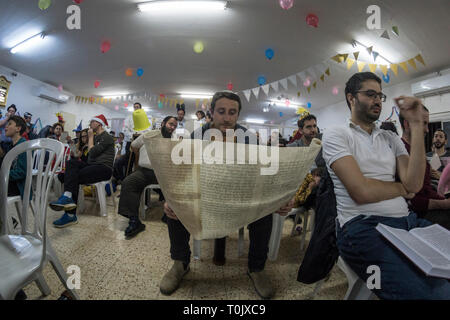 Elkana, Israel. 20 Mär, 2019. Ein Mann liest die Schriftrolle von Esther, eine Synagoge während der jüdische Feiertag Purim. In diesem Urlaub Juden traditionell verkleiden sich, lesen Sie das Buch von Esther, eine Geschichte über ein anti-jüdischen fehlgeschlagen Grundstück im alten Persien, und, wann immer ein Schläger der Name Haman, der main Antagonist, erwähnt wird. Credit: Yagil Henkin/Alamy leben Nachrichten Stockfoto