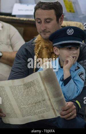 Elkana, Israel. 20 Mär, 2019. Das Lesen der Schriftrolle von Esther, eine Synagoge während der jüdische Feiertag Purim. In diesem Urlaub Juden traditionell verkleiden sich, lesen Sie das Buch von Esther, eine Geschichte über ein anti-jüdischen fehlgeschlagen Grundstück im alten Persien, und, wann immer ein Schläger der Name Haman, der main Antagonist, erwähnt wird. Credit: Yagil Henkin/Alamy leben Nachrichten Stockfoto