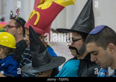 Elkana, Israel. 20 Mär, 2019. Das Lesen der Schriftrolle von Esther, eine Synagoge während der jüdische Feiertag Purim. In diesem Urlaub Juden traditionell verkleiden sich, lesen Sie das Buch von Esther, eine Geschichte über ein anti-jüdischen fehlgeschlagen Grundstück im alten Persien, und, wann immer ein Schläger der Name Haman, der main Antagonist, erwähnt wird. Credit: Yagil Henkin/Alamy leben Nachrichten Stockfoto