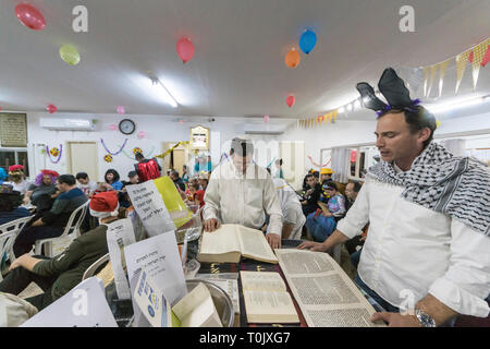 Elkana, Israel. 20 Mär, 2019. Lesung des Blättern von Esther, eine Synagoge während der jüdische Feiertag Purim. In diesem Urlaub Juden traditionell verkleiden sich, lesen Sie das Buch von Esther, eine Geschichte über ein anti-jüdischen fehlgeschlagen Grundstück im alten Persien, und, wann immer ein Schläger der Name Haman, der main Antagonist, erwähnt wird. Credit: Yagil Henkin/Alamy leben Nachrichten Stockfoto