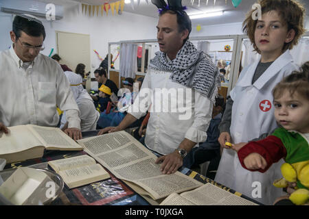 Elkana, Israel. 20 Mär, 2019. Lesung des Blättern von Esther, eine Synagoge während der jüdische Feiertag Purim. In diesem Urlaub Juden traditionell verkleiden sich, lesen Sie das Buch von Esther, eine Geschichte über ein anti-jüdischen fehlgeschlagen Grundstück im alten Persien, und, wann immer ein Schläger der Name Haman, der main Antagonist, erwähnt wird. Credit: Yagil Henkin/Alamy leben Nachrichten Stockfoto