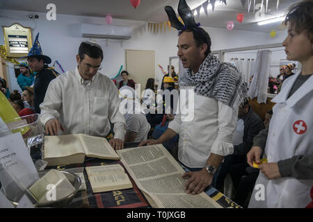 Elkana, Israel. 20 Mär, 2019. Lesung des Blättern von Esther, eine Synagoge während der jüdische Feiertag Purim. In diesem Urlaub Juden traditionell verkleiden sich, lesen Sie das Buch von Esther, eine Geschichte über ein anti-jüdischen fehlgeschlagen Grundstück im alten Persien, und, wann immer ein Schläger der Name Haman, der main Antagonist, erwähnt wird. Credit: Yagil Henkin/Alamy leben Nachrichten Stockfoto