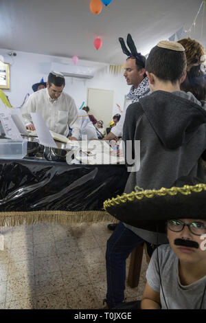 Elkana, Israel. 20 Mär, 2019. Lesung des Blättern von Esther, eine Synagoge während der jüdische Feiertag Purim. In diesem Urlaub Juden traditionell verkleiden sich, lesen Sie das Buch von Esther, eine Geschichte über ein anti-jüdischen fehlgeschlagen Grundstück im alten Persien, und, wann immer ein Schläger der Name Haman, der main Antagonist, erwähnt wird. Credit: Yagil Henkin/Alamy leben Nachrichten Stockfoto