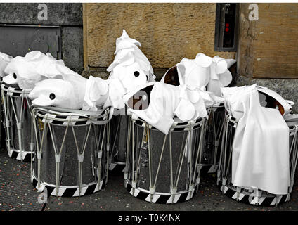 Weiß Harlekin Masken und Schlagzeug nach links an einer Straßenecke während der Basler Fasnacht, während die Teilnehmer in der Mittagspause. Stockfoto