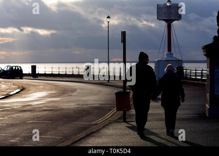 Älter, Paar, gehen, entlang, Strand, Meer, früh, Frühling, Sonne, Wetter, Besitz, Hände, kalt, Abend, Licht, Ägypten, Cowes, Isle of Wight, England, U Stockfoto