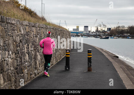 Frau in Rosa joggen auf einem Wanderweg Stockfoto