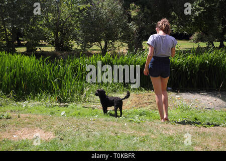 Teenager im Garten mit Ihr Cockapoo Hund am Fluss Stour Gillingham Dorset England Stockfoto