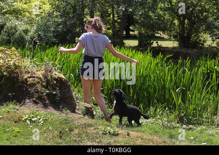 Teenager im Garten mit Ihr Cockapoo Hund am Fluss Stour Gillingham Dorset England Stockfoto