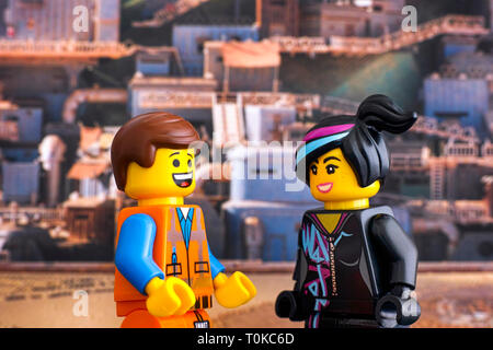 Tambow, Russische Föderation - Februar 24, 2019 Lego harten Hut Emmet und Lucy minifiguren an einander suchen und Lachen gegen Apocalypseburg backgro Stockfoto