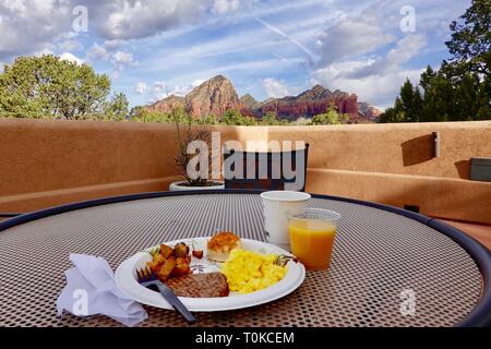 Frühstück, Kaffee und Orangensaft auf einer Terrasse im Freien Tisch mit Blick auf die Red Rock Mountains, Sedona, AZ. Stockfoto