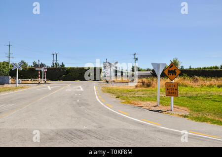 Bahnübergang in der Region Canterbury auf Neuseeland. Land bahnuebergang oder Barriere. Für Züge unterzeichnen. Dampfmaschine Grafik Stockfoto