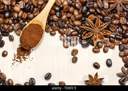 Geröstete Kaffeebohnen mit aromatischen Gewürz Sternanis auf Licht Tabelle, Ansicht von oben. Stockfoto