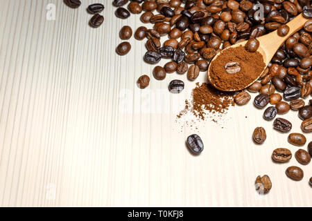 Geröstete Kaffeebohnen und gemahlener Kaffee in hölzernen Löffel auf Leuchtkasten. Nahaufnahme mit Platz für Text. Stockfoto