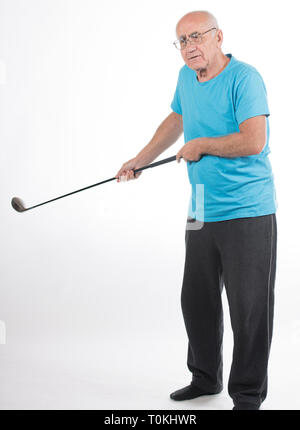 Älterer Mann im blauen T-Shirt auf weißem Hintergrund spielt Golf Stockfoto