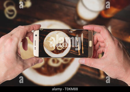 Mann, Foto der traditionellen tschechischen Gulasch mit Knödeln und Bier auf dunklen Tabelle Ansicht von oben Stockfoto