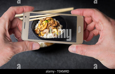 Mann, Foto der Chinesischen Reis mit Rindfleisch und vegetagles auf dunklem Hintergrund Stockfoto