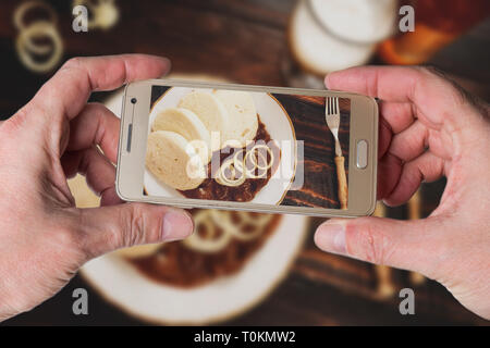 Mann, Foto der traditionellen tschechischen Gulasch mit Knödeln und Bier auf dunklen Tabelle Ansicht von oben Stockfoto