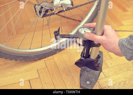 Nahaufnahme von einem Mann pumpen Fahrrad Rad. Home Wartung von Fahrrad. Fahrrad Service und Wartung für die neue Saison. Stockfoto