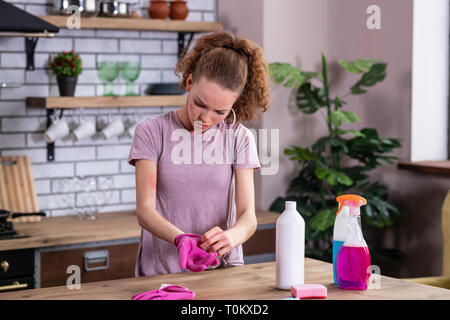 Distressed junge Frau aus Gummi rosa Handschuhe Stockfoto