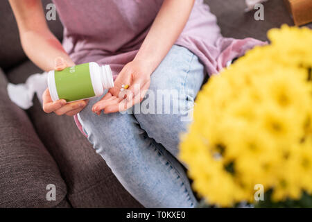 Frau, die in Jeans und T-Shirt die besondere Pillen für Allergiker Stockfoto