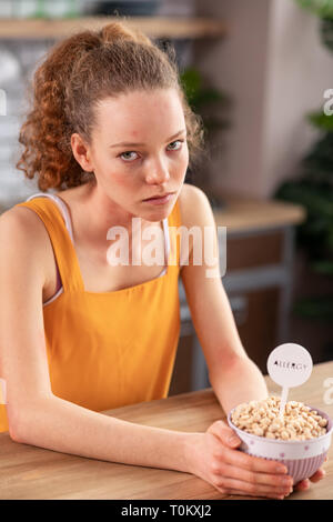 Unglücklich lockigen dunkelhaarigen Mädchen, unzufriedener mit Essen in der Schüssel Stockfoto