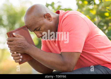 Reifen African American man beten und die Bibel lesen. Stockfoto