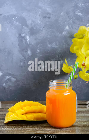 Mango Smoothie in einem Glas und frischer Mango auf einer hölzernen Hintergrund. Mango schütteln. Tropische Früchte Konzept. Stockfoto