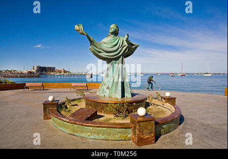 Eine mexikanische Mann, sein Fahrrad in der Nähe von einem der vielen Skulpturen, die Malecon Punkt- und Hafengebiet an der Bucht von La Paz in Baja, Mexico. Stockfoto