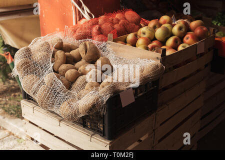 Kartoffeln und Äpfel lokal auf den Outdoor Bauernmarkt in Holzkisten platziert gewachsen Stockfoto